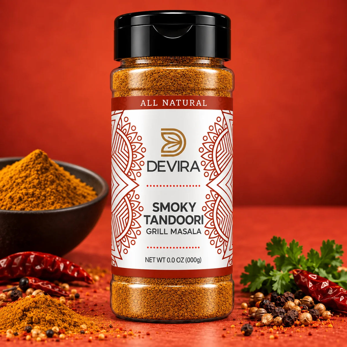 A bottle of Devira Smoky Tandoori Grill Masala spice mix centered on a warm red-orange background, with a bowl of powder, dried red chilies, and parsley around it.