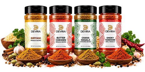 Four Devra brand masala spice jars arranged in a row with bowls of colorful ground spices, garlic, parsley, and whole spices on a white background.